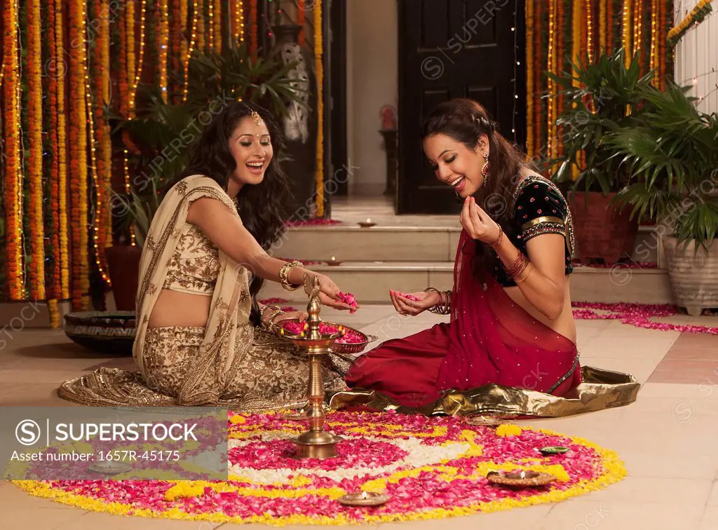Female friends making rangoli on Diwali