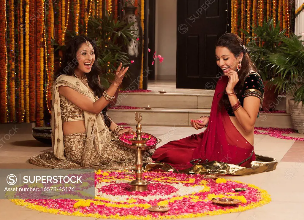 Female friends playing with flowers on Diwali