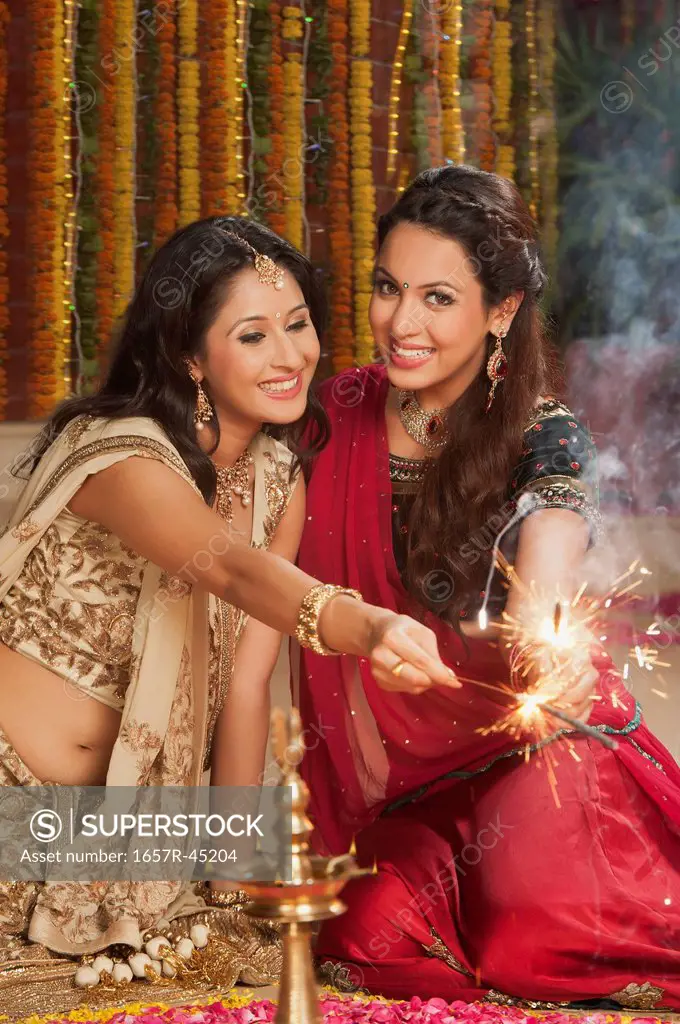 Female friends burning fire crackers on Diwali