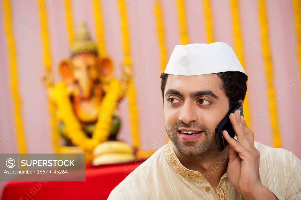 Maharashtrian man talking on a cell phone during Ganesh Chaturthi festival