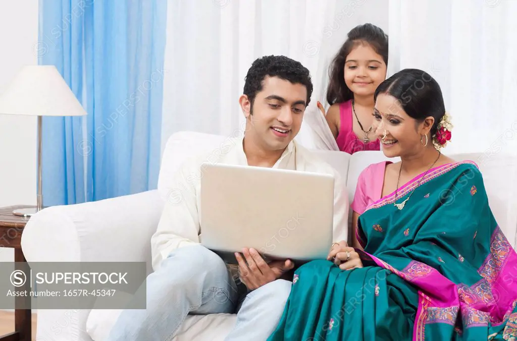 Couple using a laptop with their daughter