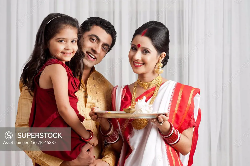 Portrait of a Bengali family with a plate of religious offerings
