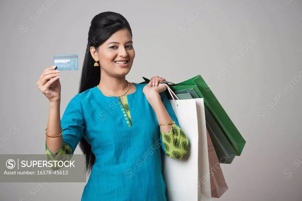 Woman holding shopping bags and showing a credit card