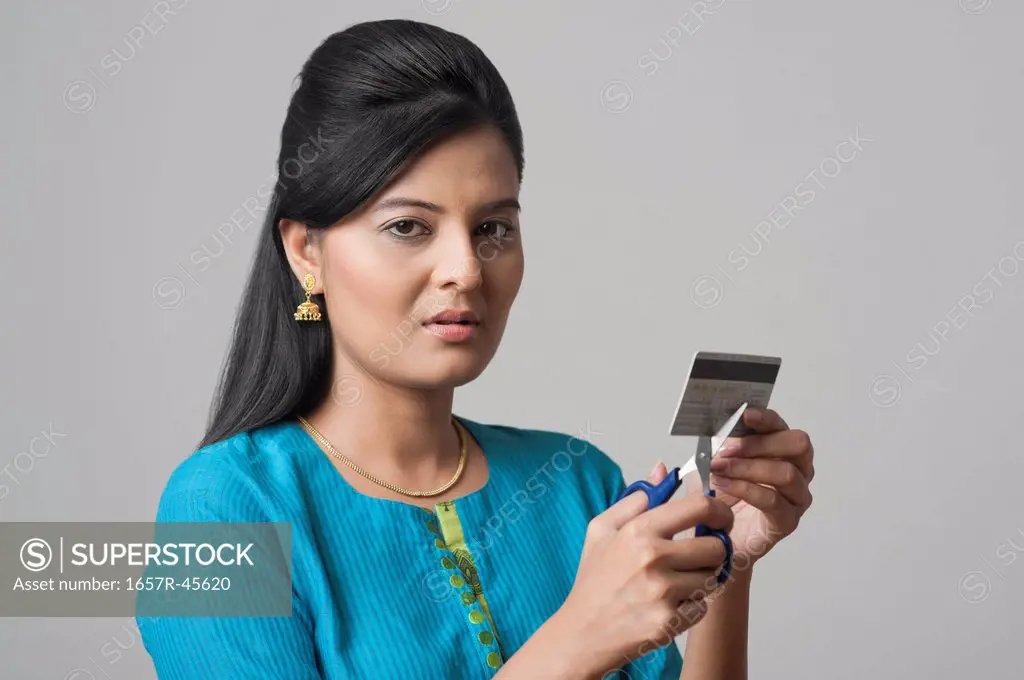 Woman cutting a credit card with scissors