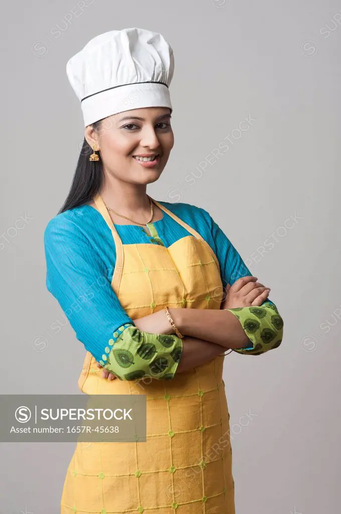 Woman wearing a chef's hat standing with his arms crossed and smiling
