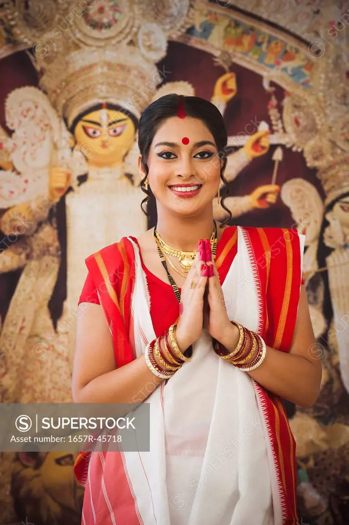 Bengali woman standing in a prayer position at Durga Puja