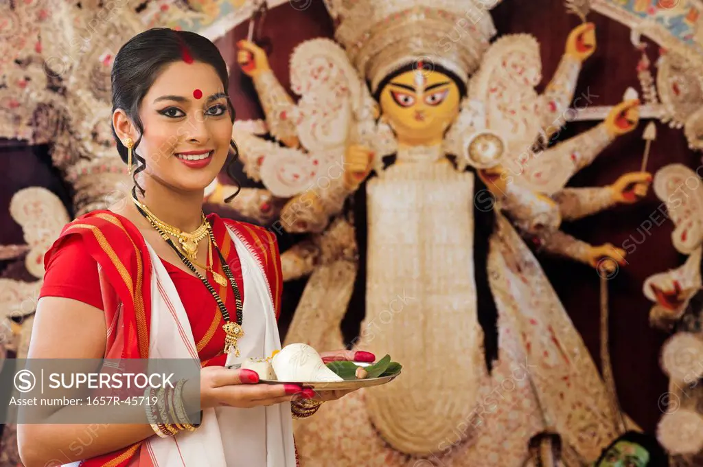Bengali woman holding a puja thali at Durga Puja