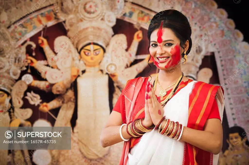 Bengali woman standing in a prayer position at Durga Puja