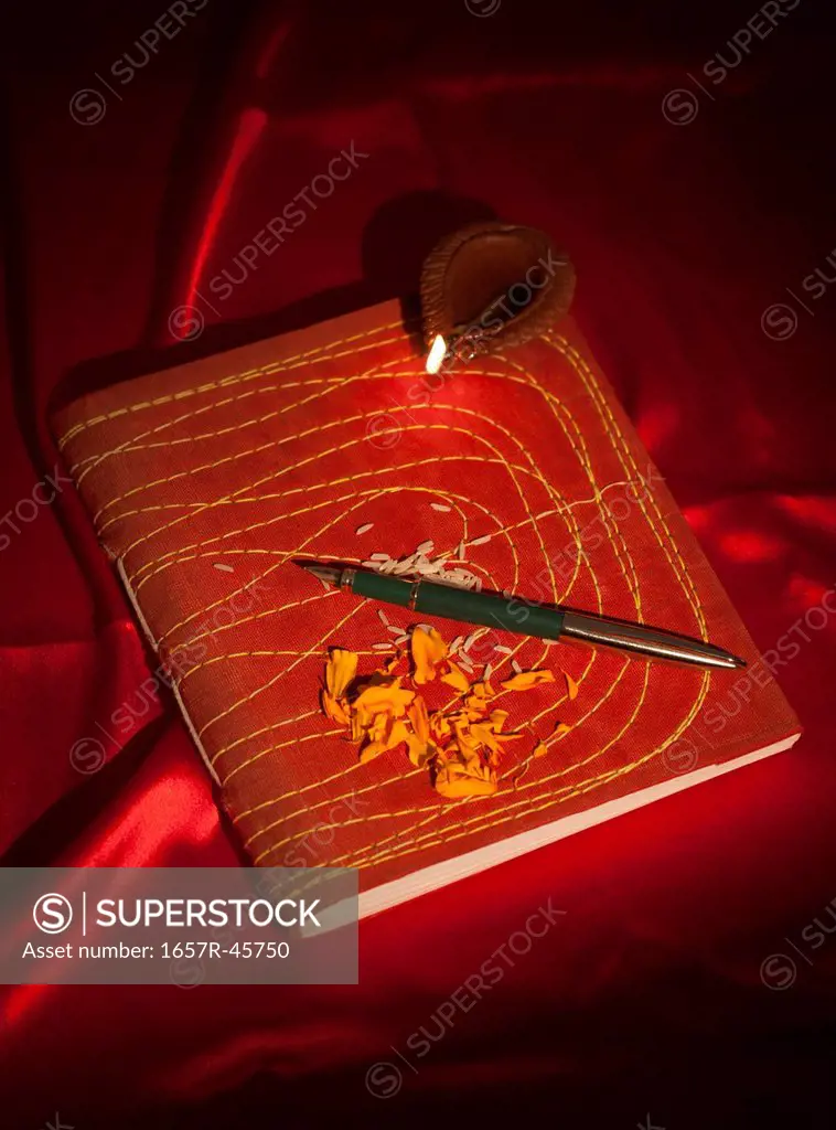 Diwali diya and a pen on ledger book during Diwali festival