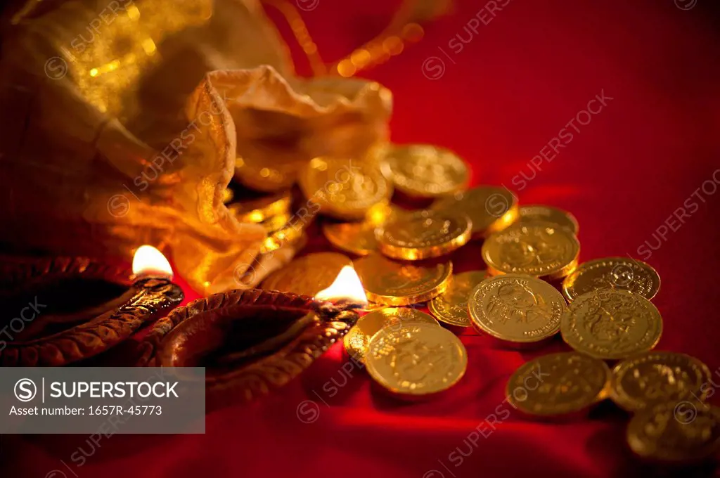 Diwali oil lamps with golden coins during Diwali festival