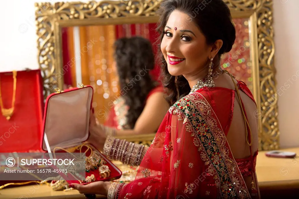 Portrait of a bridal woman holding a jewelry box and smiling