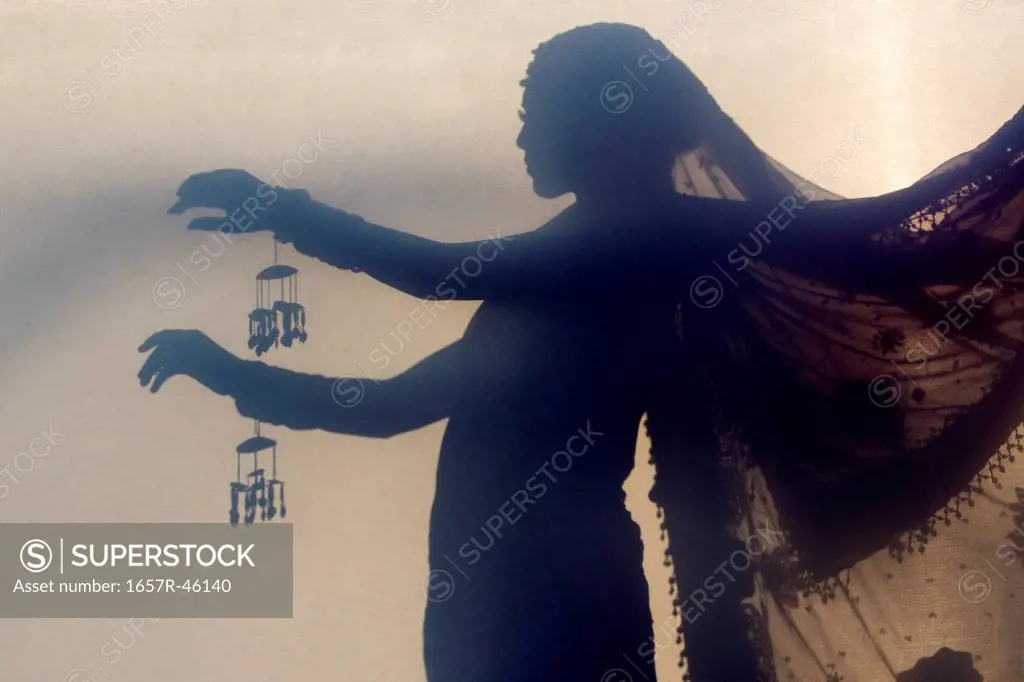 Silhouette of Indian bride in traditional wedding dress and posing