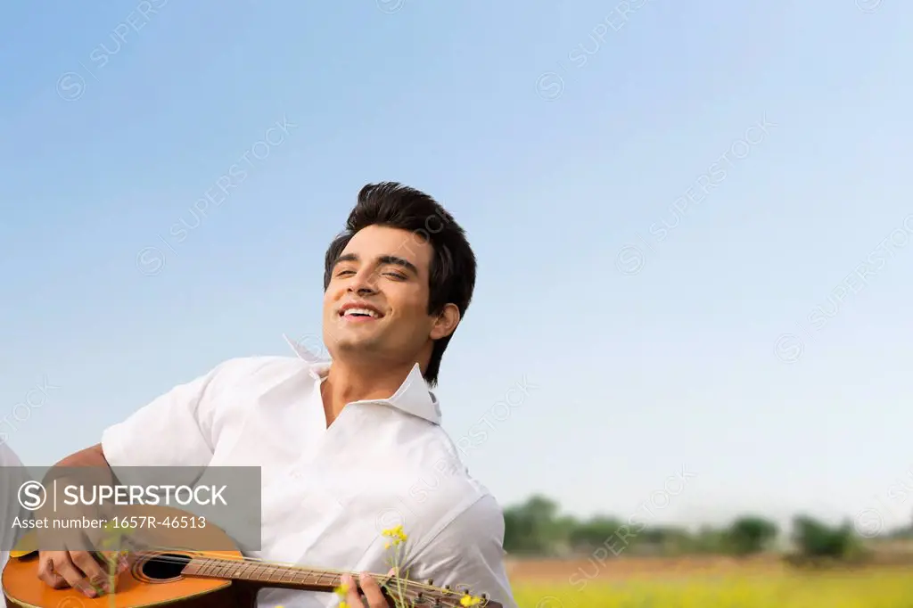 Man playing a mandolin and smiling