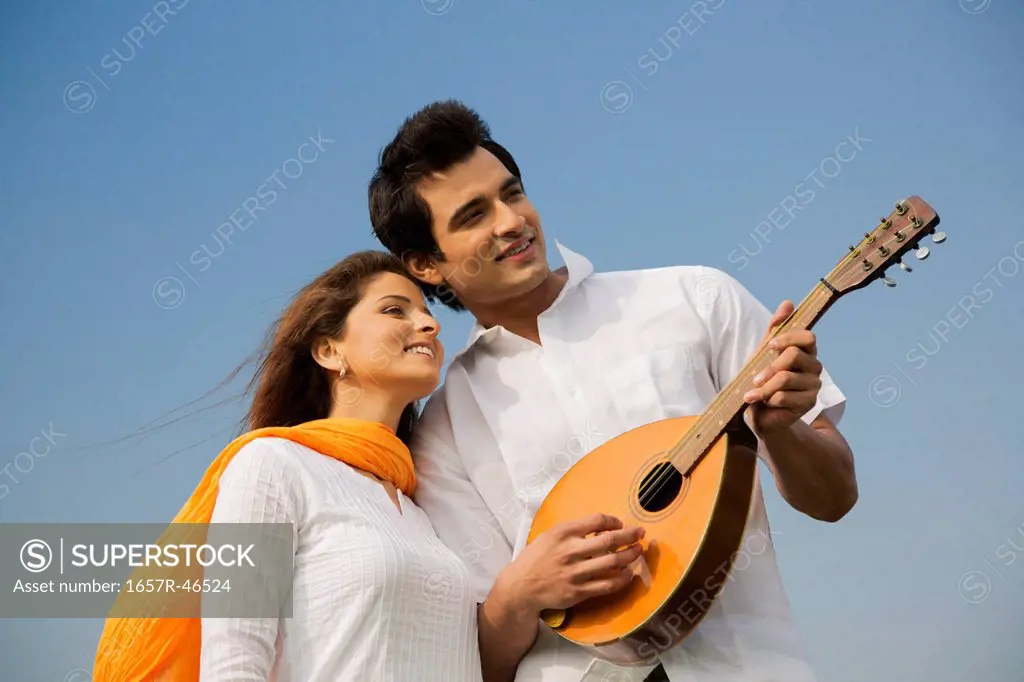 Couple playing a mandolin and smiling