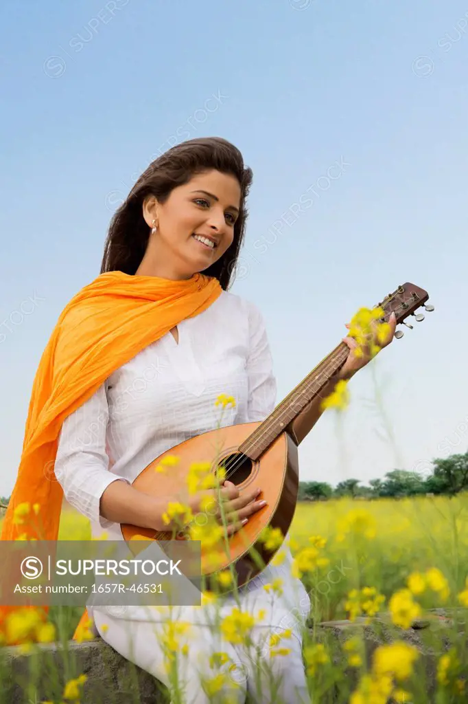 Woman playing a mandolin and smiling