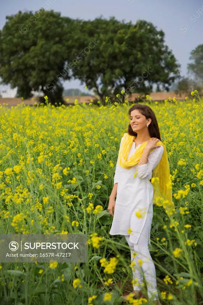 Young woman standing in a mustard field
