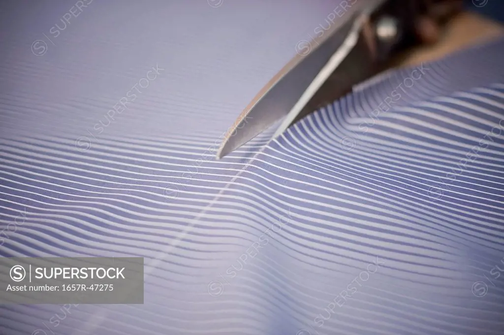 Close-up of a fabric being cut by scissors
