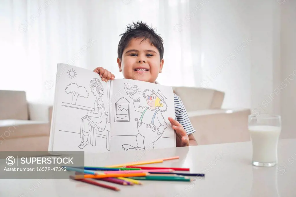 Portrait of a boy showing a coloring book
