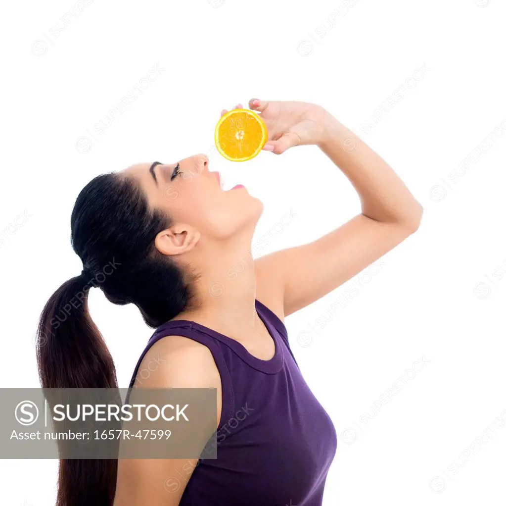 Woman drinking juice from an orange