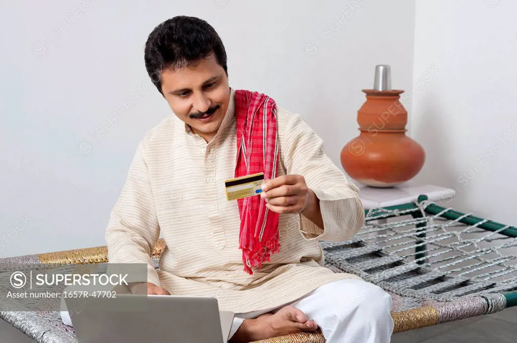 Farmer doing online shopping with a credit card