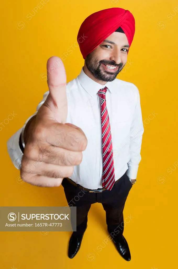 High angle view of a businessman showing thumbs up sign and smiling