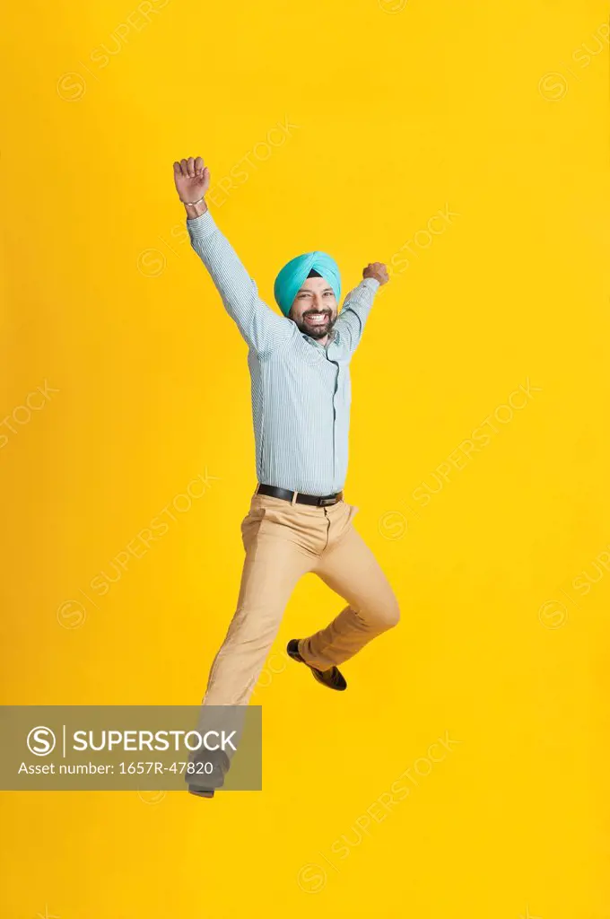 Excited Sikh man jumping and smiling