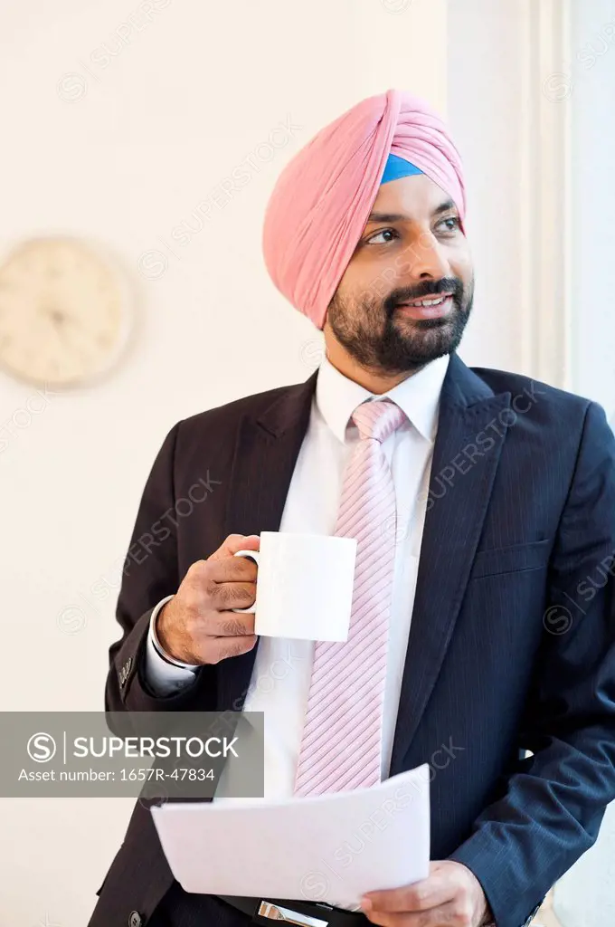 Businessman drinking coffee and holding a document
