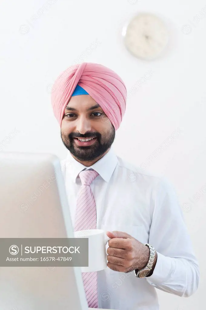 Businessman drinking coffee and working on a computer