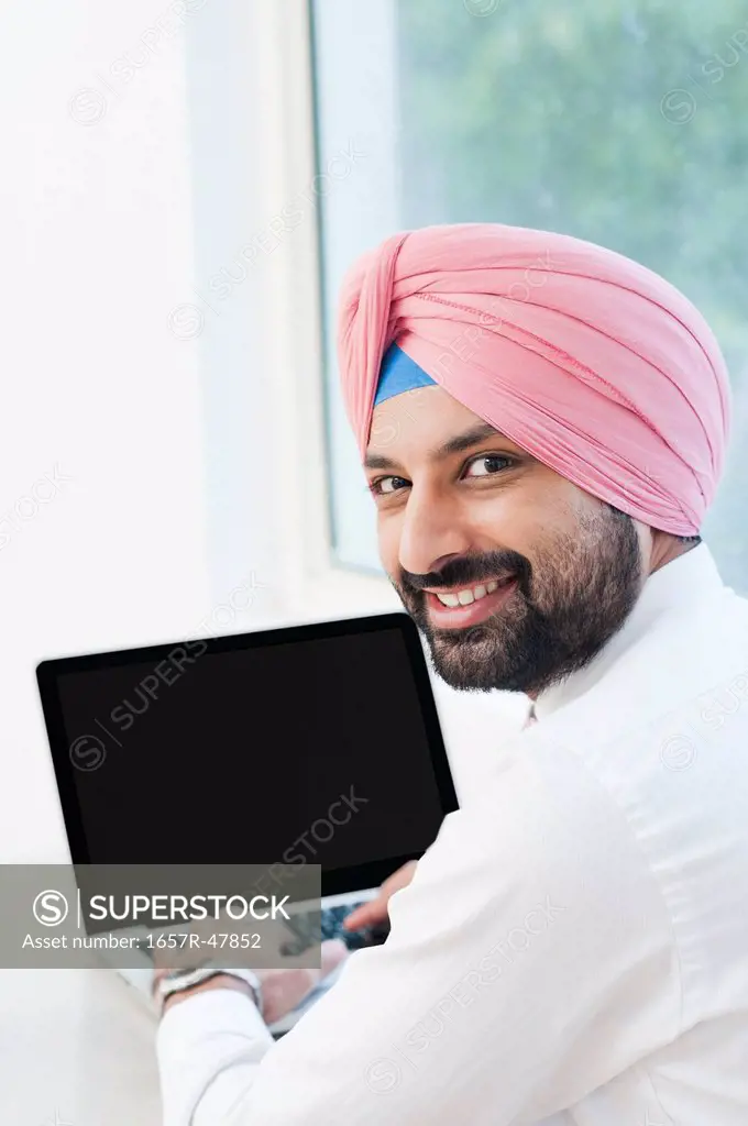 Businessman using a laptop and smiling