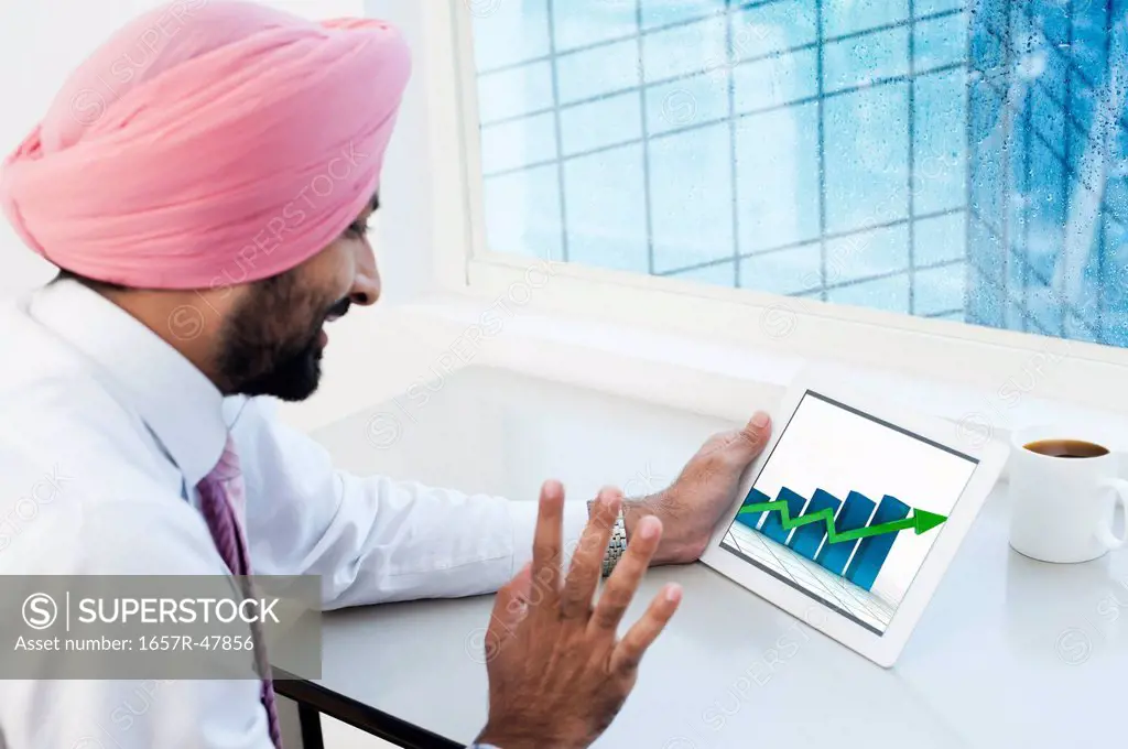 Businessman analyzing graph on a digital tablet
