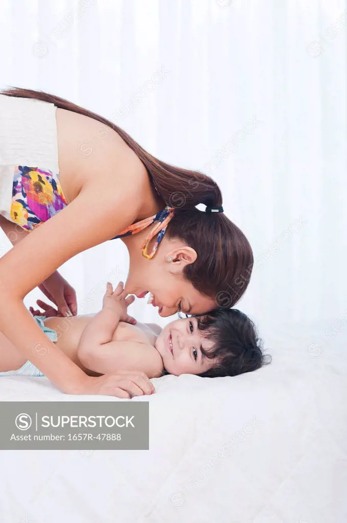 Woman playing with her son on the bed