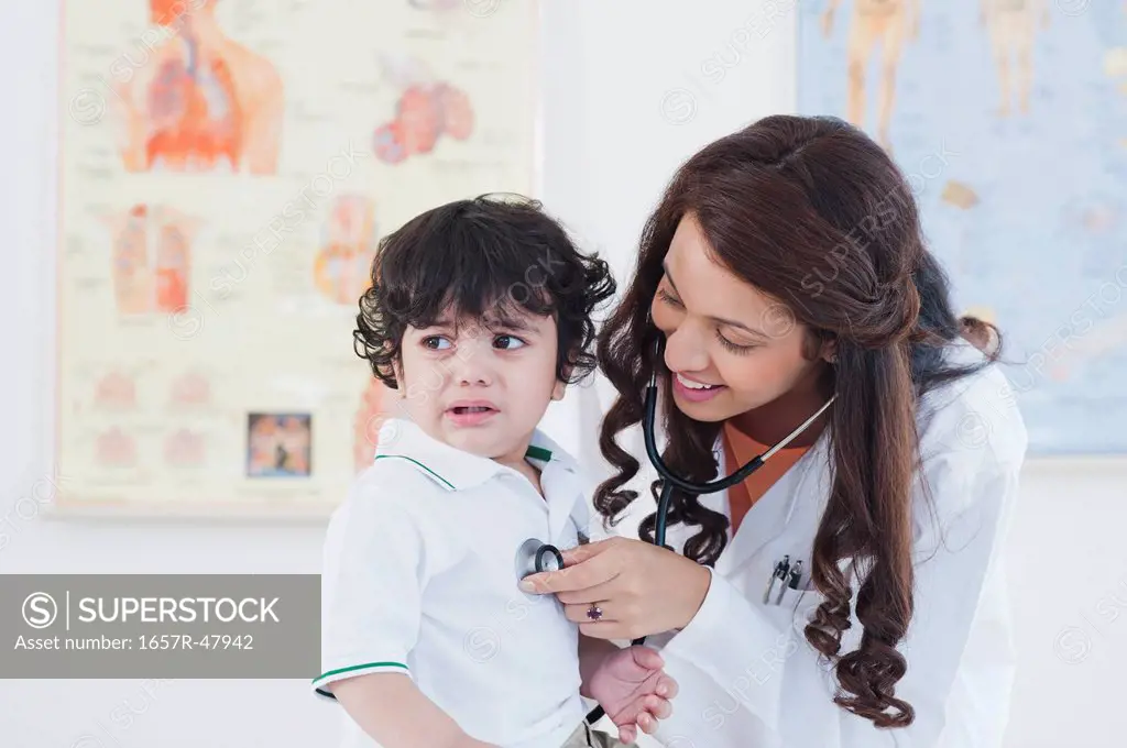 Female doctor examining a baby boy with a stethoscope