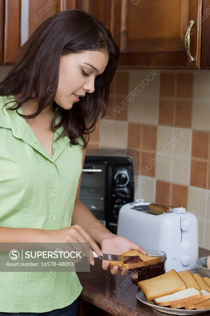 Woman putting jam on a bread