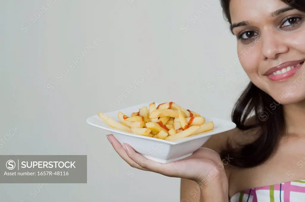 Woman holding French fries in a bowl
