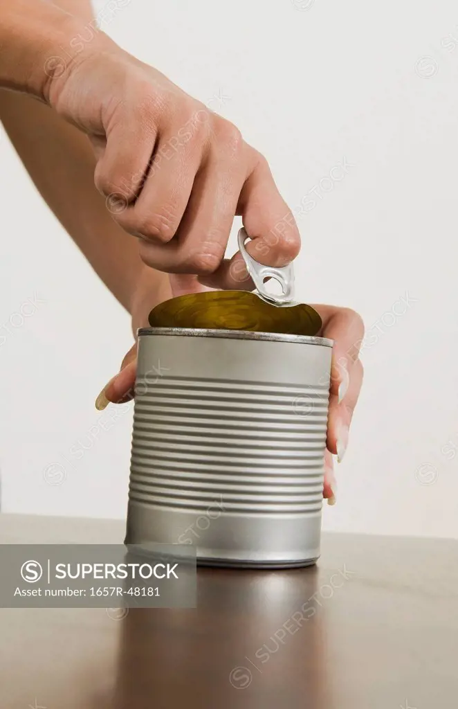 Close-up of a woman's hands opening a canned food