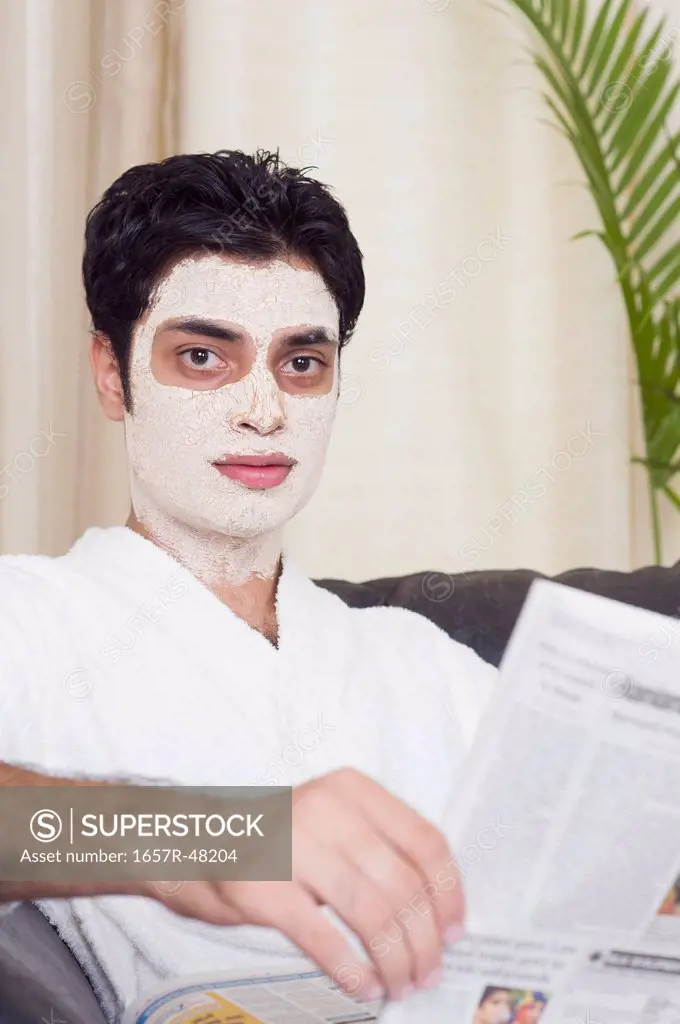 Man with facial mask reading a newspaper