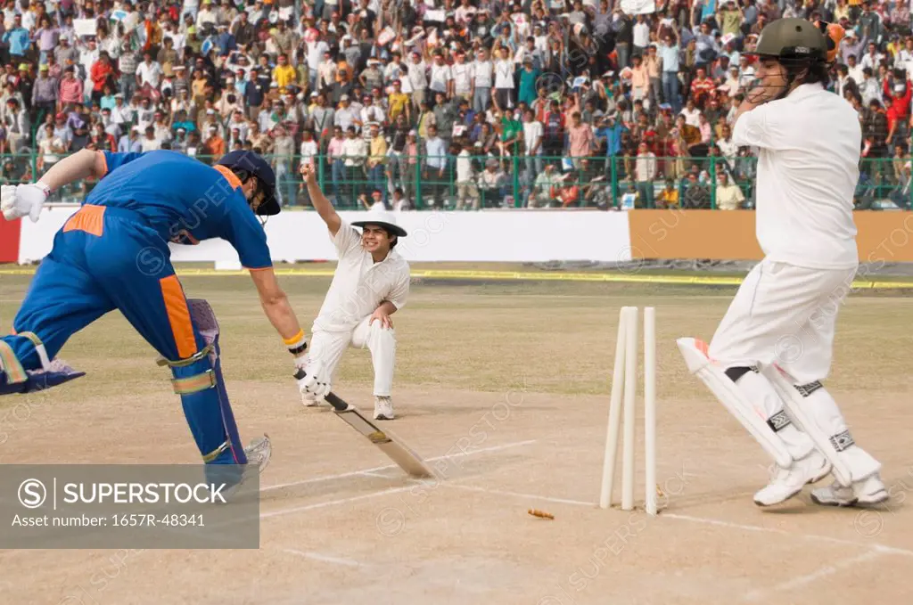 Cricket batsman scoring a run and fielder appealing for run out