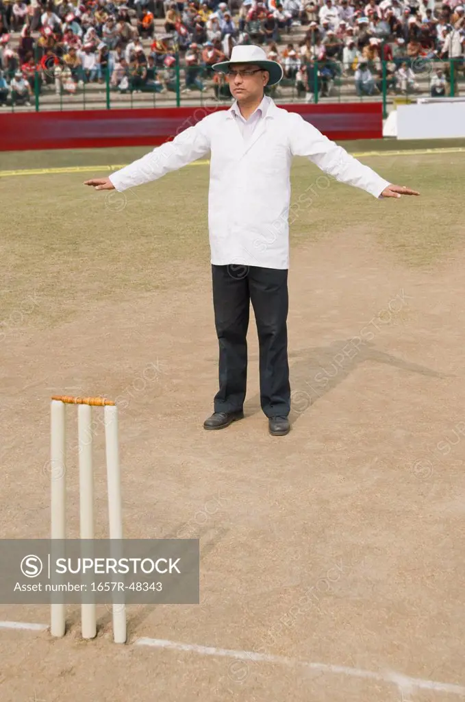 Cricket umpire signaling Wide Ball