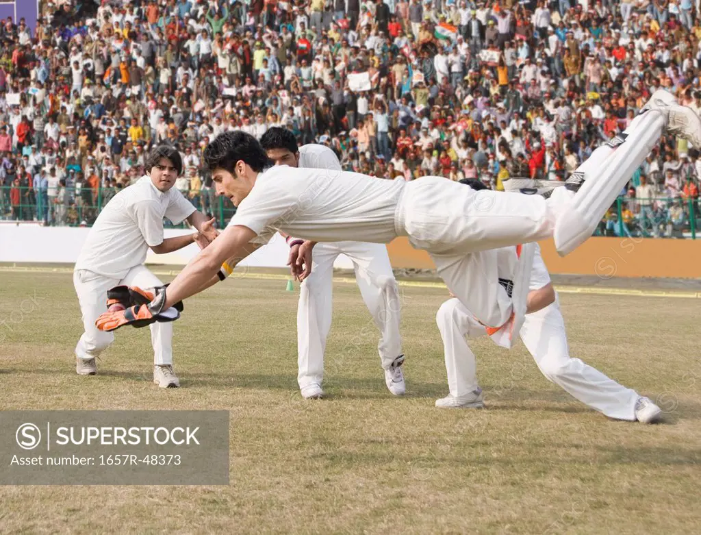 Cricket wicket keeper and fielders attempting for a catch