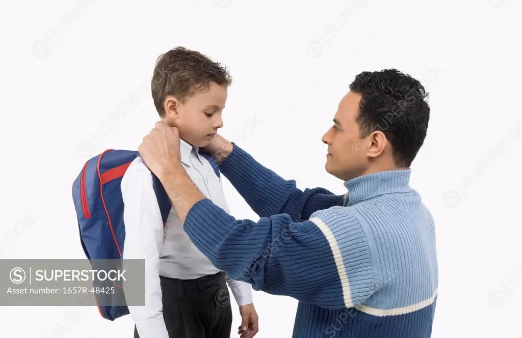 Man adjusting collar of his son