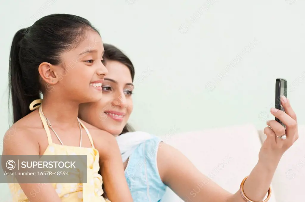 Woman and her daughter taking a picture of themselves with a mobile phone