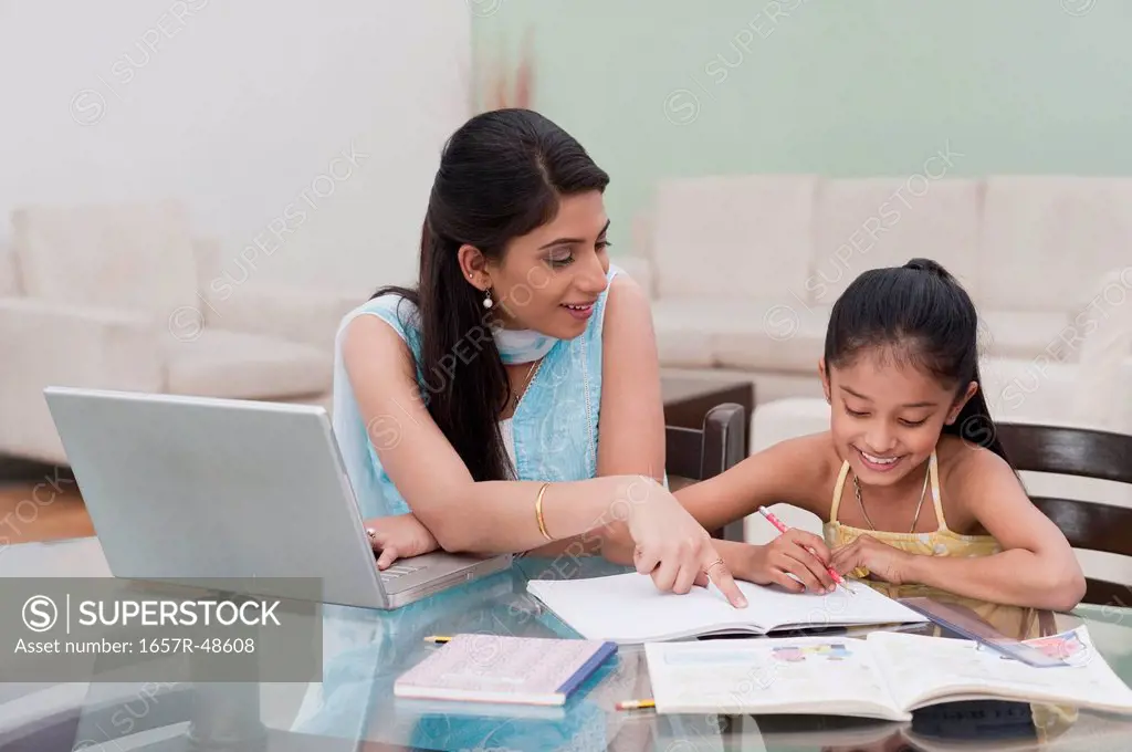 Woman helping her daughter in studies