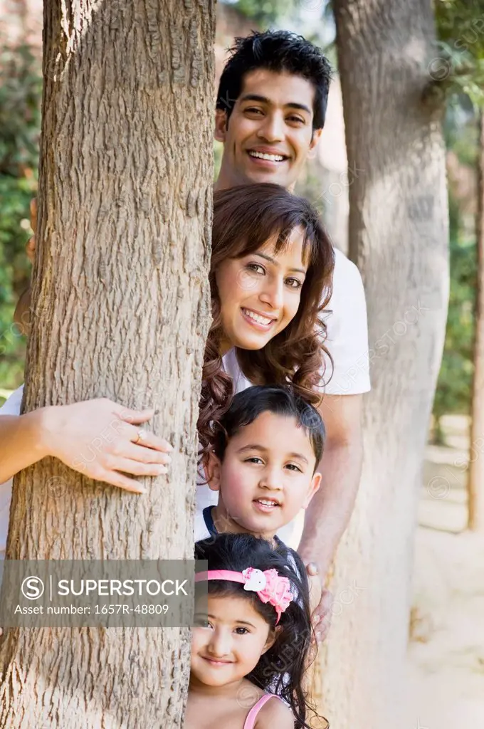 Portrait of a family smiling near a tree, Gurgaon, Haryana, India