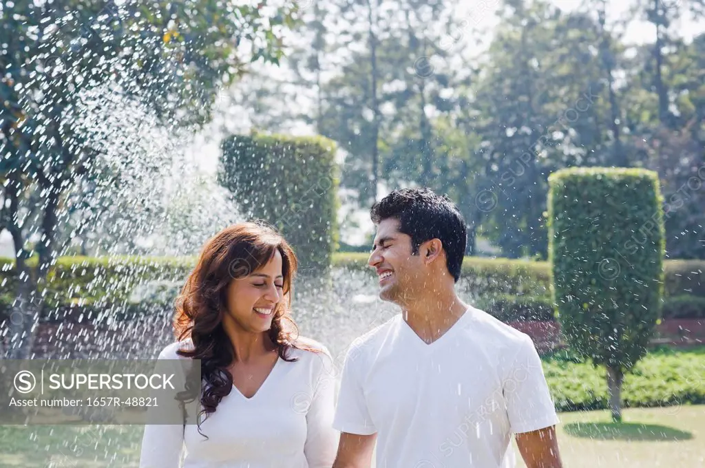 Couple romancing near a sprinkler, Gurgaon, Haryana, India
