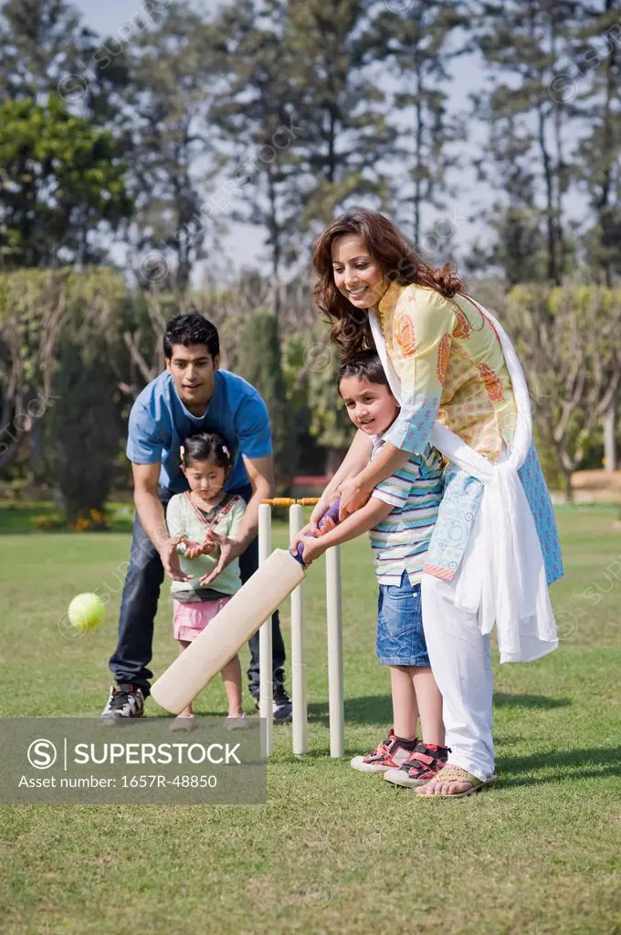 Family playing cricket in a lawn, Gurgaon, Haryana, India