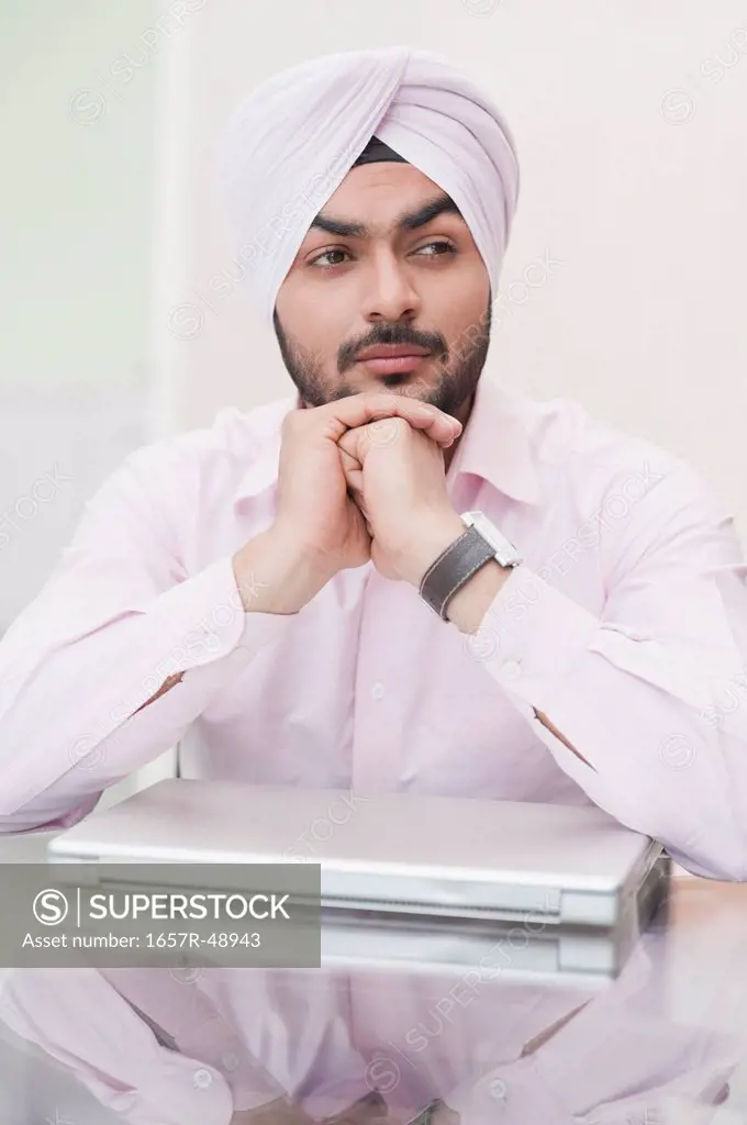 Businessman thinking in front of a laptop