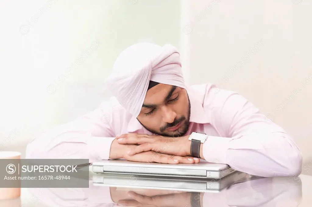 Businessman napping on a laptop