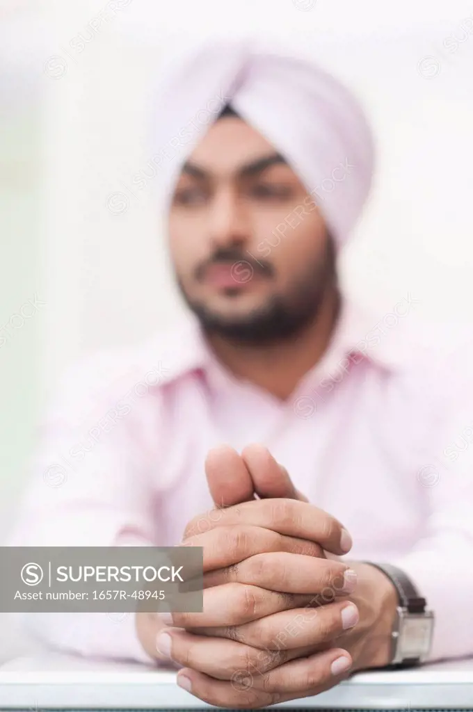 Businessman thinking with hands clasped