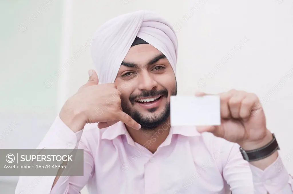 Businessman holding a blank business card and showing Call Me gesture