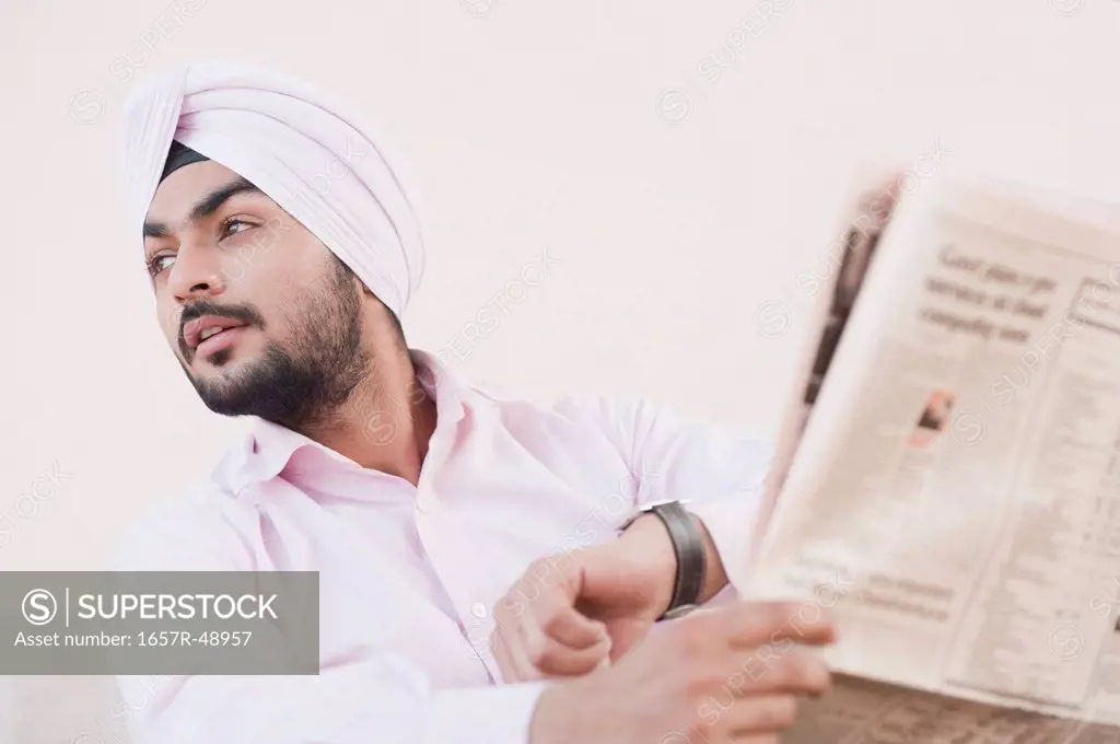Businessman holding a newspaper and looking away